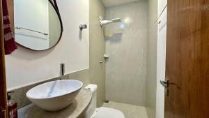 a bathroom with a sink and a toilet and a mirror at Flat Guarapari Praia das Castanheiras e Areia in Guarapari +25 photos