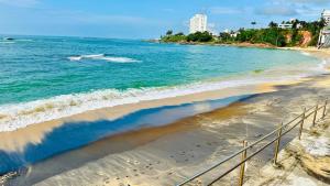 a view of a beach with a boat in the water at Flat Guarapari Praia das Castanheiras e Areia in Guarapari