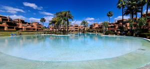 duży basen w ośrodku z palmami w obiekcie Alhambra del Golf - Guadalmina w mieście Estepona