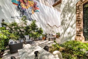 a patio with a table and chairs and a mural at UTOPIC Campos Elíseos by ULIV in Mexico City +16 photos