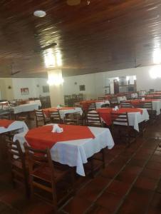 a dining room with red and white tables and chairs at Flat Cavalinho Branco 119 in Águas de Lindoia