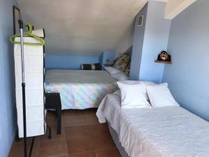 a small bedroom with two beds and a desk at El Bosque Rural House in El Bosque