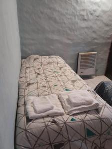 Una cama con toallas en una habitación en Casita Roxy, en San Carlos de Bariloche