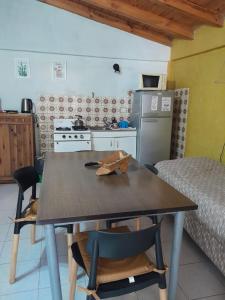 cocina con mesa y sillas y cocina con nevera en Casita Roxy, en San Carlos de Bariloche