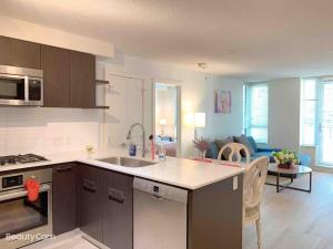 eine Küche mit Spüle und ein Wohnzimmer in der Unterkunft Cozy Perfect &elegant 2bed 1 bath in Richmond center in Richmond