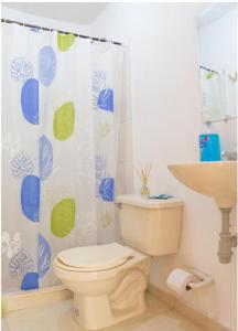 a bathroom with a toilet and a shower curtain at Blue Pearl Cartagena in Cartagena de Indias