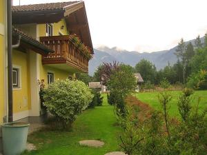 ein Haus mit einem Balkon und einem grünen Hof in der Unterkunft Aberseehaus Nussbaumer in Strobl