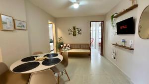 una sala da pranzo con tavolo e sedie di Quadra do Mar 2 Quartos Suite Praia do Morro Guarapari a Guarapari