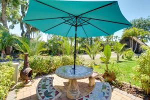 a table with a blue umbrella on a patio at Cabin with Boat Launch and Pool Access in Okeechobee in Okeechobee