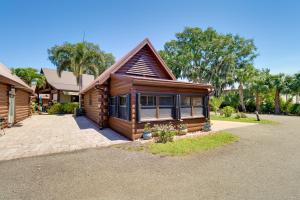 a log cabin with a driveway in front of a house at Cabin with Boat Launch and Pool Access in Okeechobee in Okeechobee