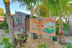 a sign in front of a house with palm trees at Cabin with Boat Launch and Pool Access in Okeechobee in Okeechobee