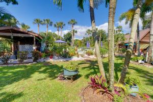 a yard with a chair and palm trees at Cabin with Boat Launch and Pool Access in Okeechobee in Okeechobee