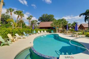 a swimming pool with lounge chairs and umbrellas at a resort at Cabin with Boat Launch and Pool Access in Okeechobee in Okeechobee