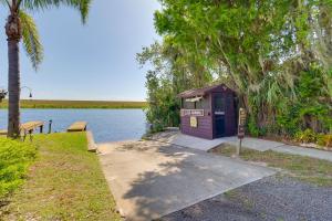 a small purple out house next to a body of water at Cabin with Boat Launch and Pool Access in Okeechobee in Okeechobee