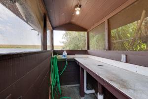 an empty room with a counter and two windows at Cabin with Boat Launch and Pool Access in Okeechobee in Okeechobee