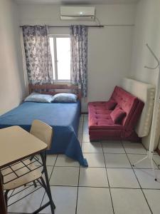 Apartamento de Praia no Centro في ايتابيما: غرفة نوم بها سرير وكرسي أحمر +23 صورة
