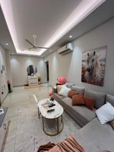 a living room with a couch and a table at Luxurious 2BHK apartment muscat bousher in Muscat