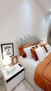 a bed with orange and white pillows in a room at Luxurious 2BHK apartment muscat bousher in Muscat