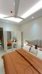 a bedroom with a large bed and a ceiling fan at Luxurious 2BHK apartment muscat bousher in Muscat