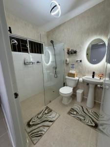 a bathroom with a shower and a toilet and a sink at Sweet dreams Tropical paradise in San Isidro