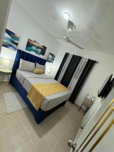 a bedroom with a bed with a blue headboard at Sweet dreams Tropical paradise in San Isidro