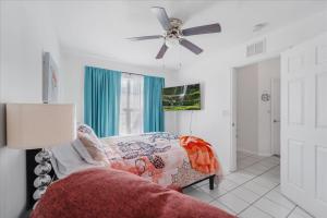 a bedroom with a bed and a ceiling fan at 5 Star, Twin Home, Heated Pool Located D-town Cape in Cape Coral