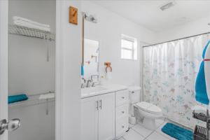 a white bathroom with a toilet and a shower at 5 Star, Twin Home, Heated Pool Located D-town Cape in Cape Coral +29 photos
