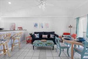 a living room with a couch and a table and chairs at 5 Star, Twin Home, Heated Pool Located D-town Cape in Cape Coral