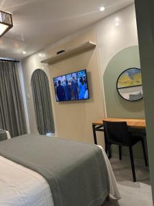 a bedroom with a bed and a table and a tv at Gran Lençóis Flat Residence Mandacaru 311 - 611 in Barreirinhas