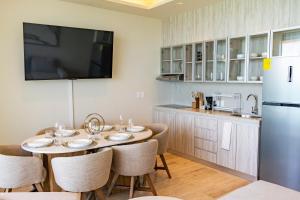 a kitchen with a table with chairs and a refrigerator at Distrito Morelos by Andiani Travel in Puerto Morelos +22 photos