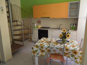 een keuken met een tafel met een vaas met bloemen erop bij Casa Vacanza il Ciliegio in Noto