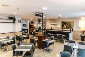 a restaurant with tables and chairs in a room at Hostal Regina in Blanes