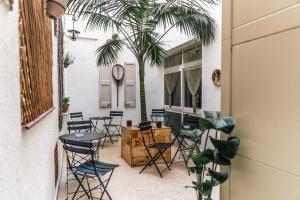 a room with chairs and a table and palm trees at Hostal Regina in Blanes