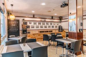 a restaurant with tables and chairs and a chalkboard at Hostal Regina in Blanes