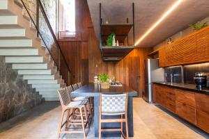a dining room with a table and chairs and stairs at Casa Bangalô dos Milagres in Passo de Camarajibe
