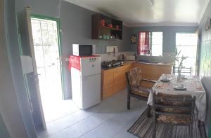 une cuisine avec une table et un réfrigérateur blanc dans l'établissement Accommodation AirB&B Fiji, à Nadi