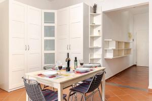 a kitchen with a table with chairs and wine bottles at Calzaiuoli Sunshine in Florence