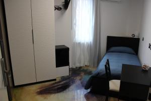 a bedroom with a bed and a table and a cabinet at Follow Me B&B in San Salvo