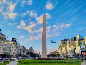 a obelisk in the middle of a city with buildings at Sarmiento Home in Buenos Aires