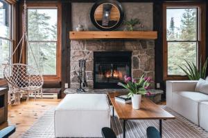 a living room with a stone fireplace at Family escape w private hot tub in Lac-Superieur
