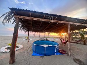 une femme est sur la plage avec une glacière bleue dans l'établissement Villas del pacífico barra de nexpa, à Caleta de Campos