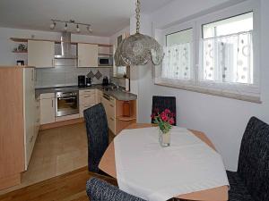 eine Küche und ein Esszimmer mit einem Tisch und Stühlen in der Unterkunft Ferienwohnung Bellgardt in Langenargen