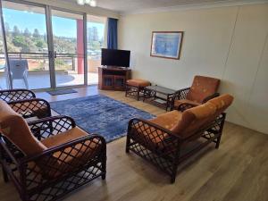 un soggiorno con sedie, tavolo e TV di Sandbar 302 - linen not included a Forster