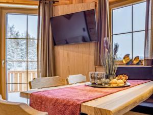 a dining room with a table with a tv and windows at Deluxe Zirberl Top 6 in Weisspriach