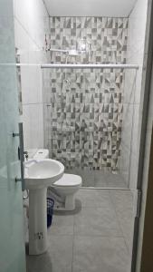 a bathroom with a toilet and a sink and a shower at Pousada Morada do Sol AP 01 in Três Marias