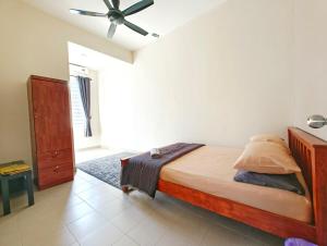a bedroom with a bed and a ceiling fan at Premium Homestay - Tol Taiping in Kamunting +8 photos