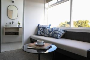 a room with a bed with a window and a table at Barrys Beach Road Hotel in Sydney