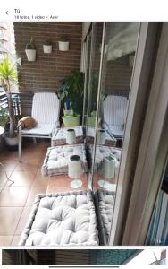 a patio with white couches and chairs on a balcony at BIENVENIDOS a CASA PINO CENTRO in Logroño