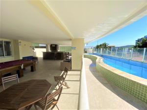 a pool deck with a pool table and a swimming pool at lindo 3qts AR Churrasqueira Piscina Centro Forte Cabo Frio in Cabo Frio