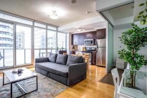 a living room with a couch and a kitchen at Spacious Condo Next To CN Tower in Toronto